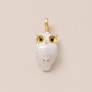 Vue détaillée d'une breloque hibou blanche avec accents dorés pour porte-clés DIY