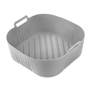 Detail shot showing a grey square silicone air fryer basket with handles and ridges
