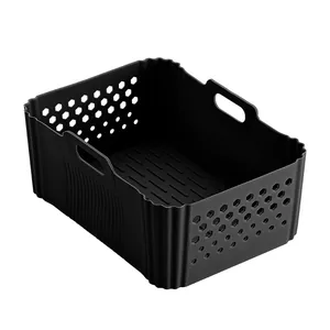 Macro detail view of a black rectangular silicone air fryer basket with handles and vents.
