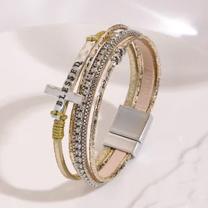 Detailed view of bohemian multilayer bracelet with BLESSED cross charm and magnetic clasp