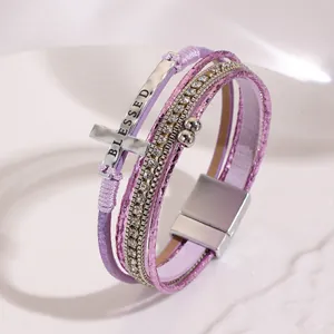 Detail view of Bohemian multi-layer leather bracelet with cross and rhinestone accents