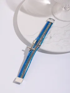 Detail view of blue multi-layer PU leather bracelet with rhinestone strips and BLESSED cross