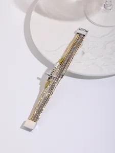 Detailed macro shot of bohemian multilayer cross bracelet with magnetic clasp and rhinestones