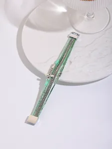 Macro detail of Bohemian multi-layer PU leather bracelet with cross charm and rhinestones