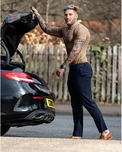 Vue d'un homme tatoué portant un polo en maille kaki ajusté à l'extérieur