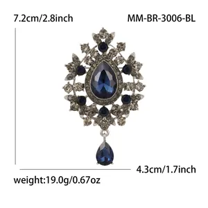 Detailed close-up of a vintage dark blue crystal brooch with an elegant teardrop pendant