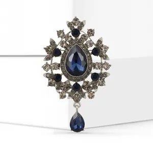 Vintage style blue teardrop glass brooch with crystal accents and a dangling pendant