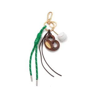 Sporty fashion bag charm featuring a pretzel and baseball with green rope keychain