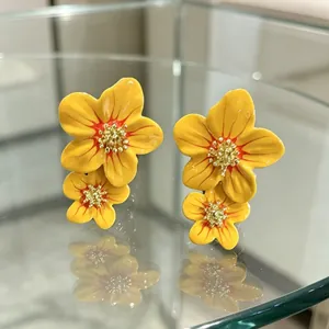 Boucles d'oreilles fleurs vintage en émail jaune avec un centre doré sur verre