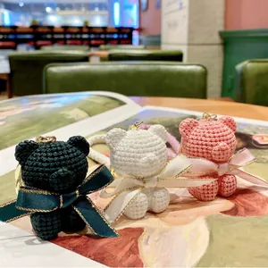 Cute resin bear keychains with knitted texture and ribbon bows in lifestyle setting