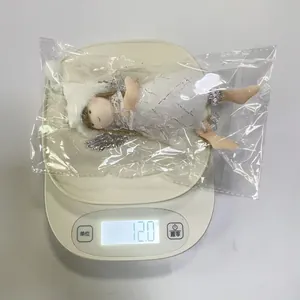 Detailed macro view showing the Christmas angel girl ornament weighing exactly 12.0g on a scale