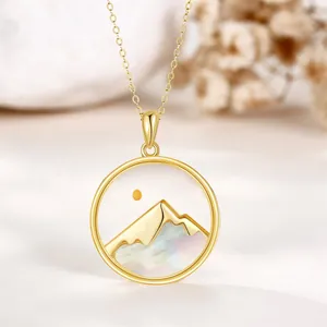 Detailed close-up of a gold mountain pendant with iridescent mother-of-pearl inlay