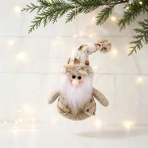 A detailed view of a plush Christmas gnome ornament hanging on a festive pine branch