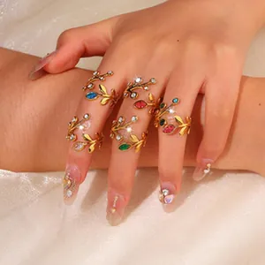 Close-up view of golden stainless steel rings featuring colorful gems in leaf design