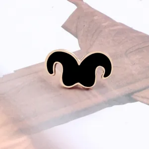 Detailed view of a stylish black enamel mustache brooch with a rose gold border