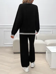 Back view of a women's black loose long-sleeve knit two-piece set with striped edges.