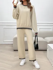 Detail view of casual beige two-piece knit set with striped trim and wide-leg pants.