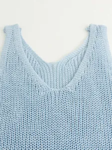 Close-up detail of light blue V-neck knitted summer vest showing delicate texture.