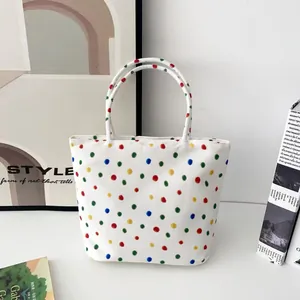 Vorderansicht einer weißen Nylon-Schultertasche mit einem lebhaften bunten Punktmuster