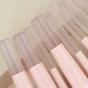 Macro detail of frosted pink makeup brush handles with minimalist design and texture