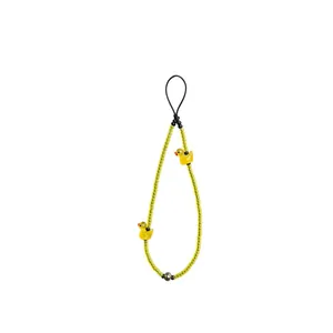 Detailed macro view of a yellow glass bead phone charm featuring two cute duck charms