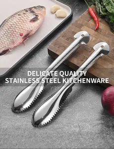 Close-up of dual stainless steel fish scalers on kitchen counter with fresh fish