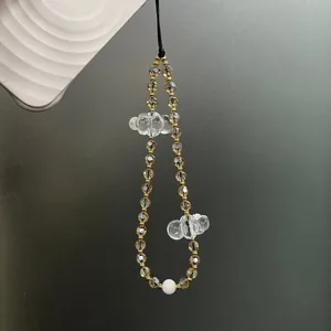 Detail of phone strap with clear acrylic clouds and champagne crystal beads