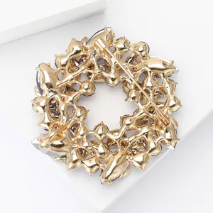 Élégante broche couronne de fleurs dorée avec cristaux bleus étincelants et dos détaillé