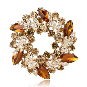 Élégante broche couronne dorée avec strass marquise ambre et zircons clairs
