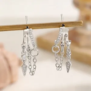 Detail shot of silver-colored zircon drop earrings with chain tassels and arrow charms