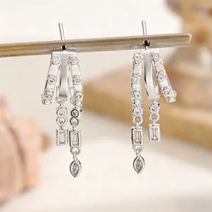 Close-up of silver dangle earrings with sparkling marquise and baguette zircons