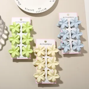Set of three matte plumeria flower hair claw clips in pastel green, yellow and blue
