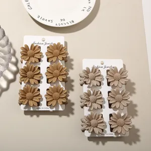Detailed macro view of matte flower hair claw clips arranged on white display cards