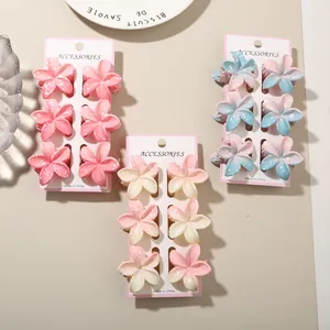 Detail view of colorful plumeria flower hair clips sets in pink, cream, and blue.