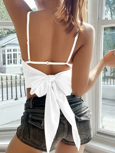 Detail view of a white Y2K camisole featuring a stylish large bow-tied back.