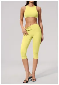Detailed shot of yellow high-waisted cropped yoga pants and matching sports top