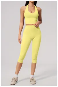 Full view of yellow high waist yoga capris set on model in minimalist studio setting