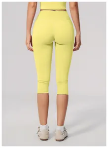 Close-up back view of yellow high-waisted yoga capri pants showing the athletic fit design