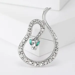 Elegant silver-toned snake brooch featuring clear rhinestones and green crystal eyes