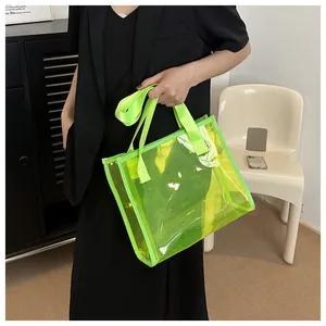 Model holding a neon green transparent PVC tote bag in a stylish minimalist setting