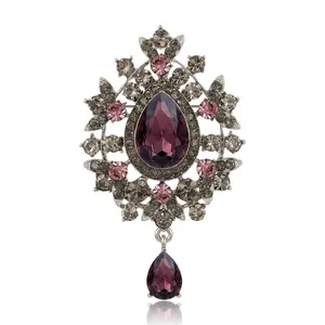 Elegant vintage silver-tone brooch featuring a large pear-shaped purple crystal pendant