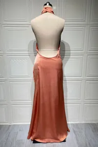 Elegant peach backless satin halter maxi dress with a sleek floor-length silhouette