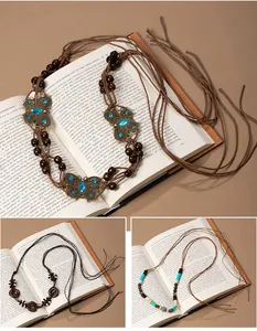 Bohemian vintage woven tassel waist chains with beads and butterfly shown on book