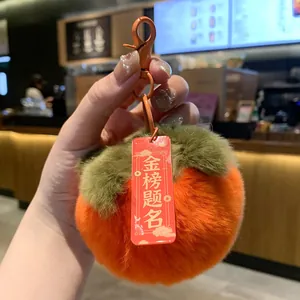 Close-up of plush persimmon keychain with red success tag detail