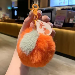 Detail of plush persimmon keychain with lucky tag and soft faux fur texture