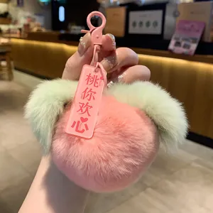 Handheld soft pink faux fur peach plush keychain charm with green leaves and heart tag