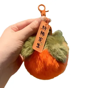Cute plush persimmon keychain charm with soft orange faux fur and green leaves