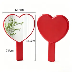 Red heart-shaped handheld makeup mirror with dimensions shown on white background.