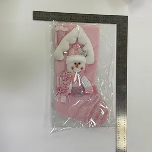 Pink sequined Christmas stocking with snowman design shown with a measuring ruler.