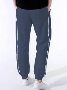 Back view of men's navy blue paratrooper pants with stylish white side stripe detail